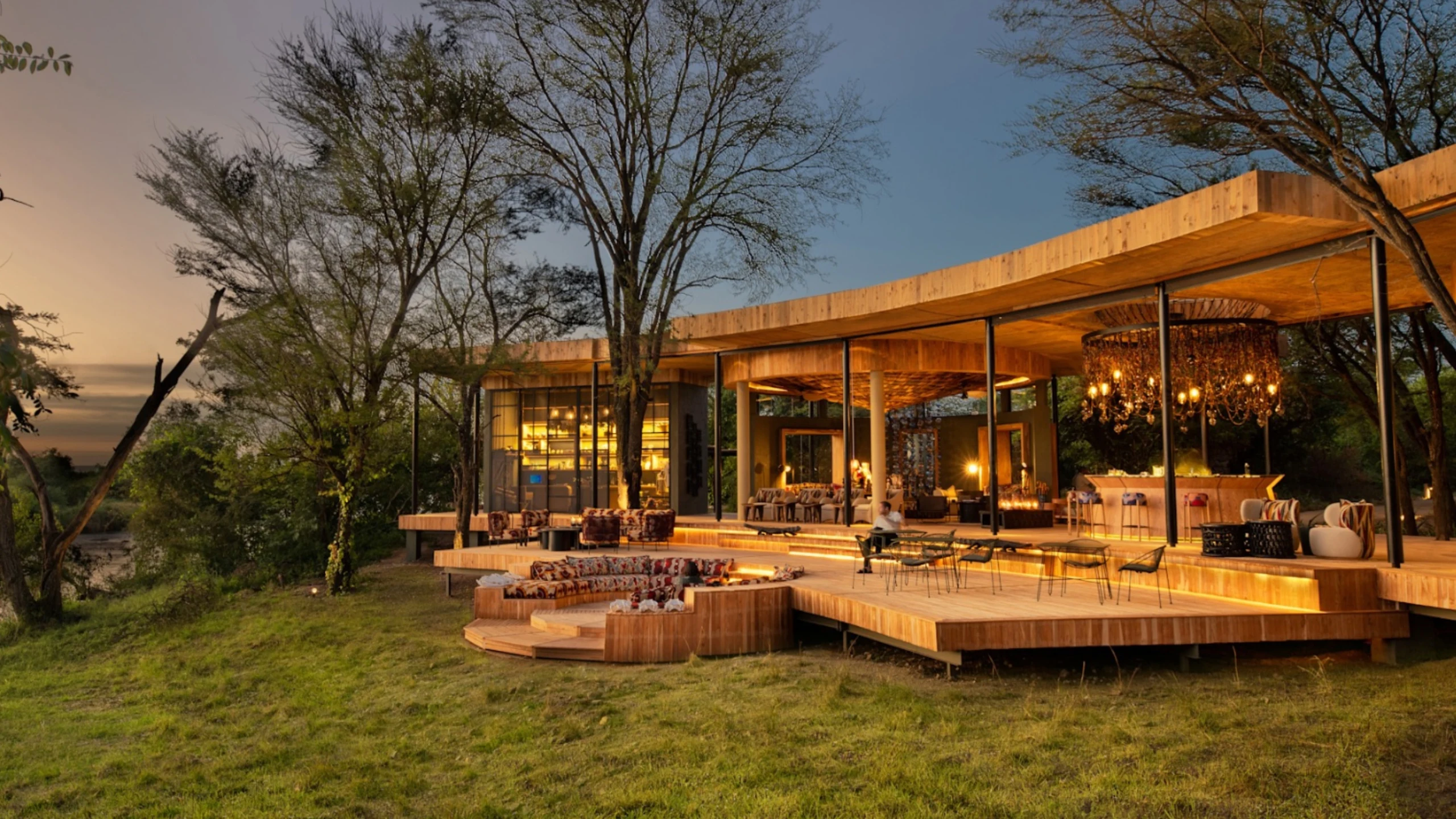 Illuminated lodge and wooden terrace at Grumeti Serengeti River Lodge