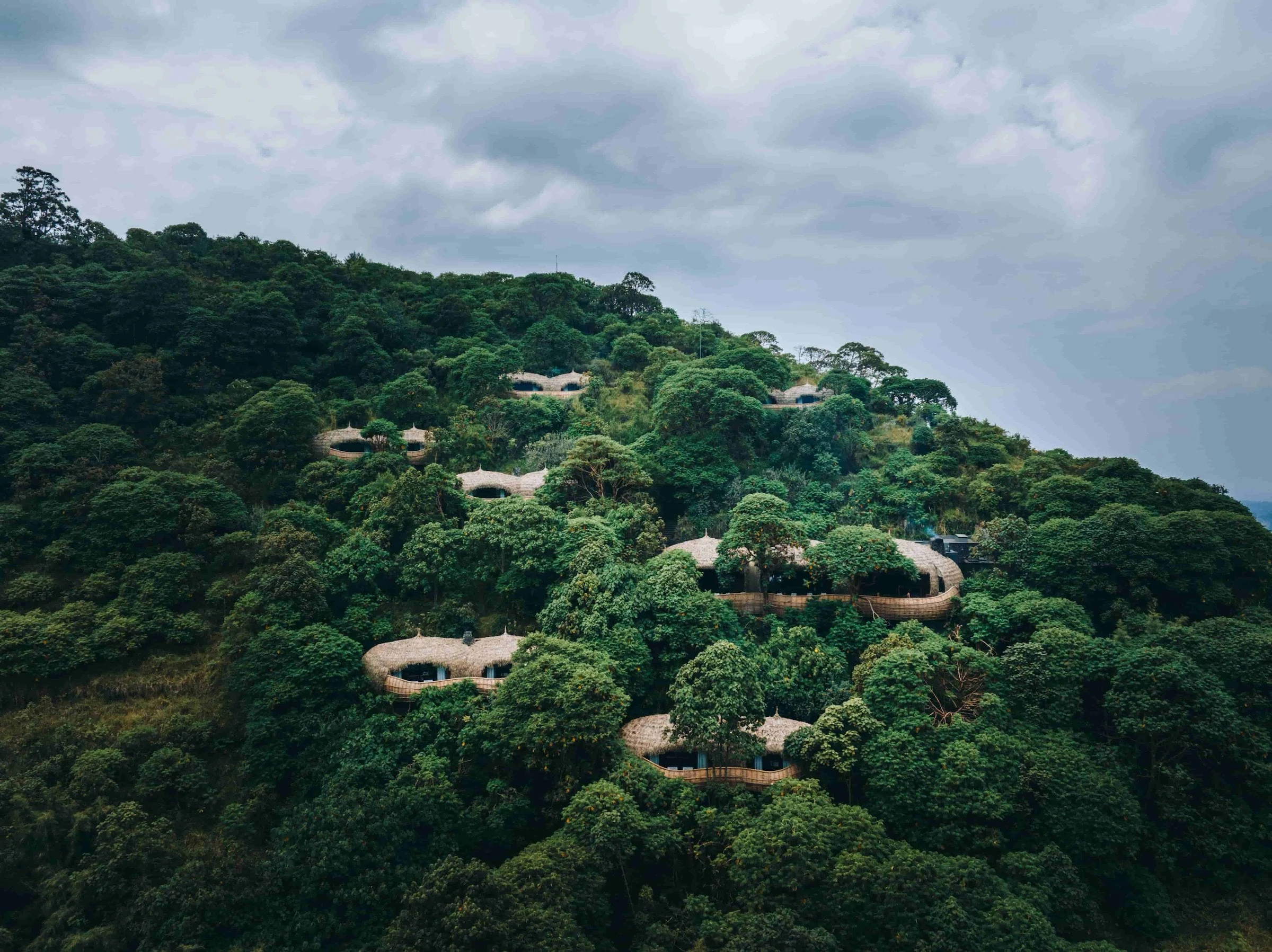 Rounded lodges amid dense wooded hills