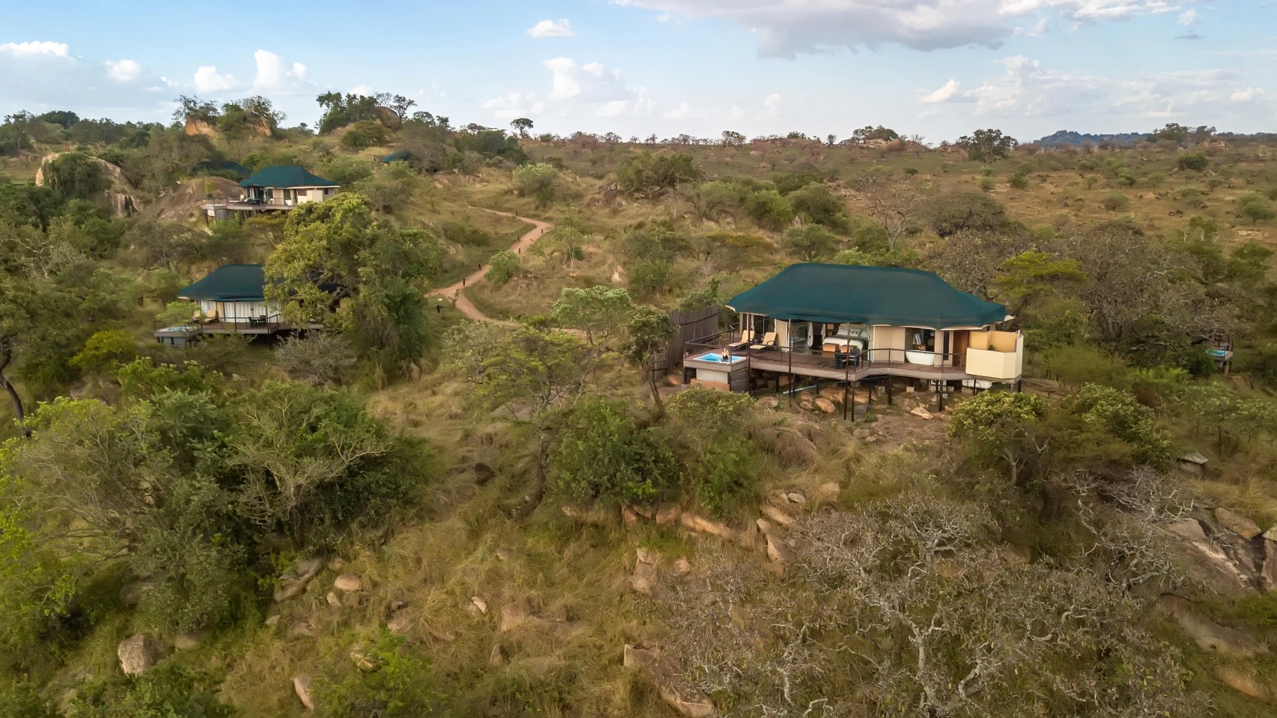 Lodge buildings across wooded hillside at Lemala Kuria Hills Lodge