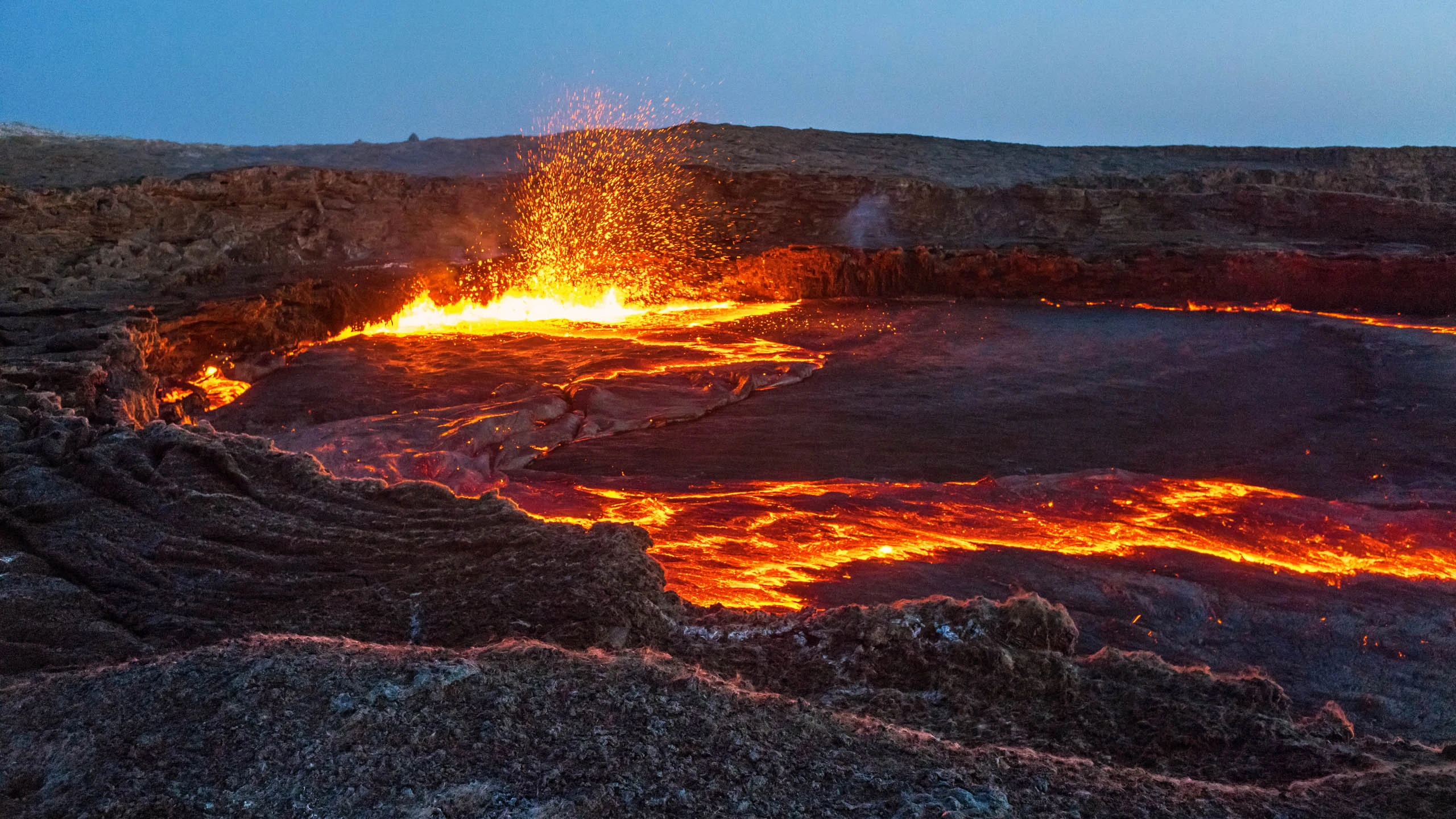 Lava lake with fountaining spray at dusk