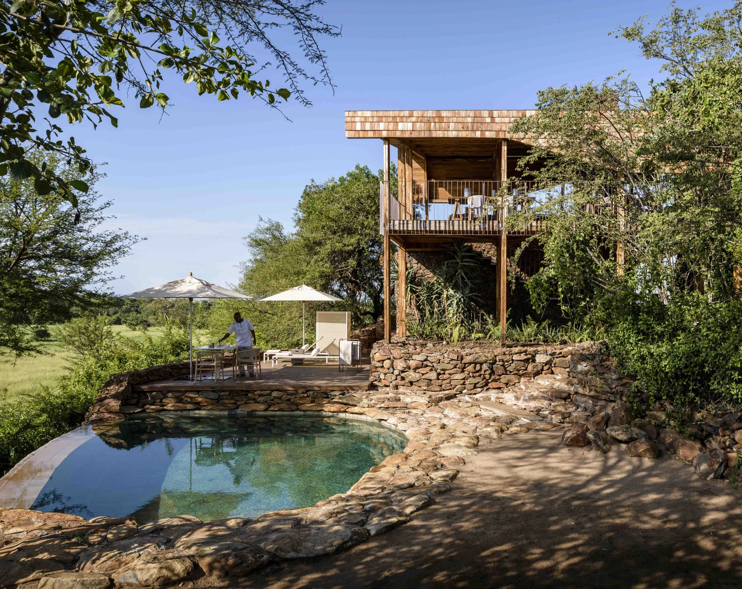 Rock edged pool beside raised lodge