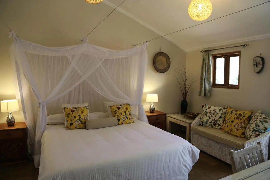 a bedroom with a white bed and a couch