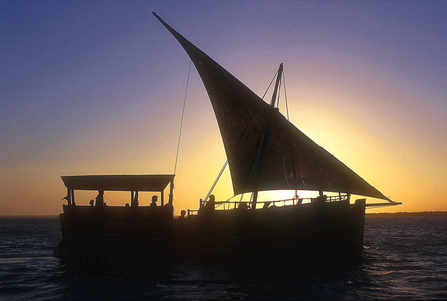 A dhow under sail at sunset off Kenya's coast