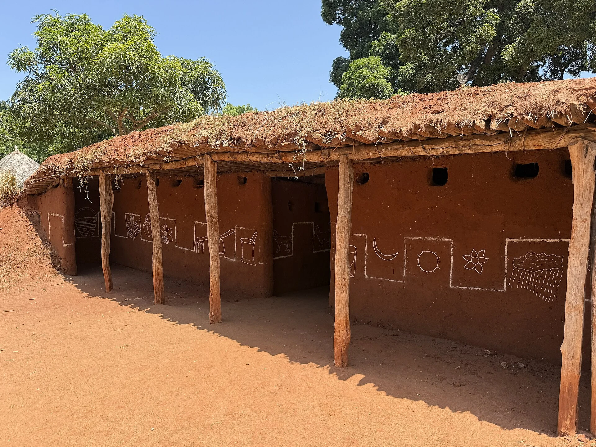 Outside of a traditional Iraqw house with mud walls and a thatched roof