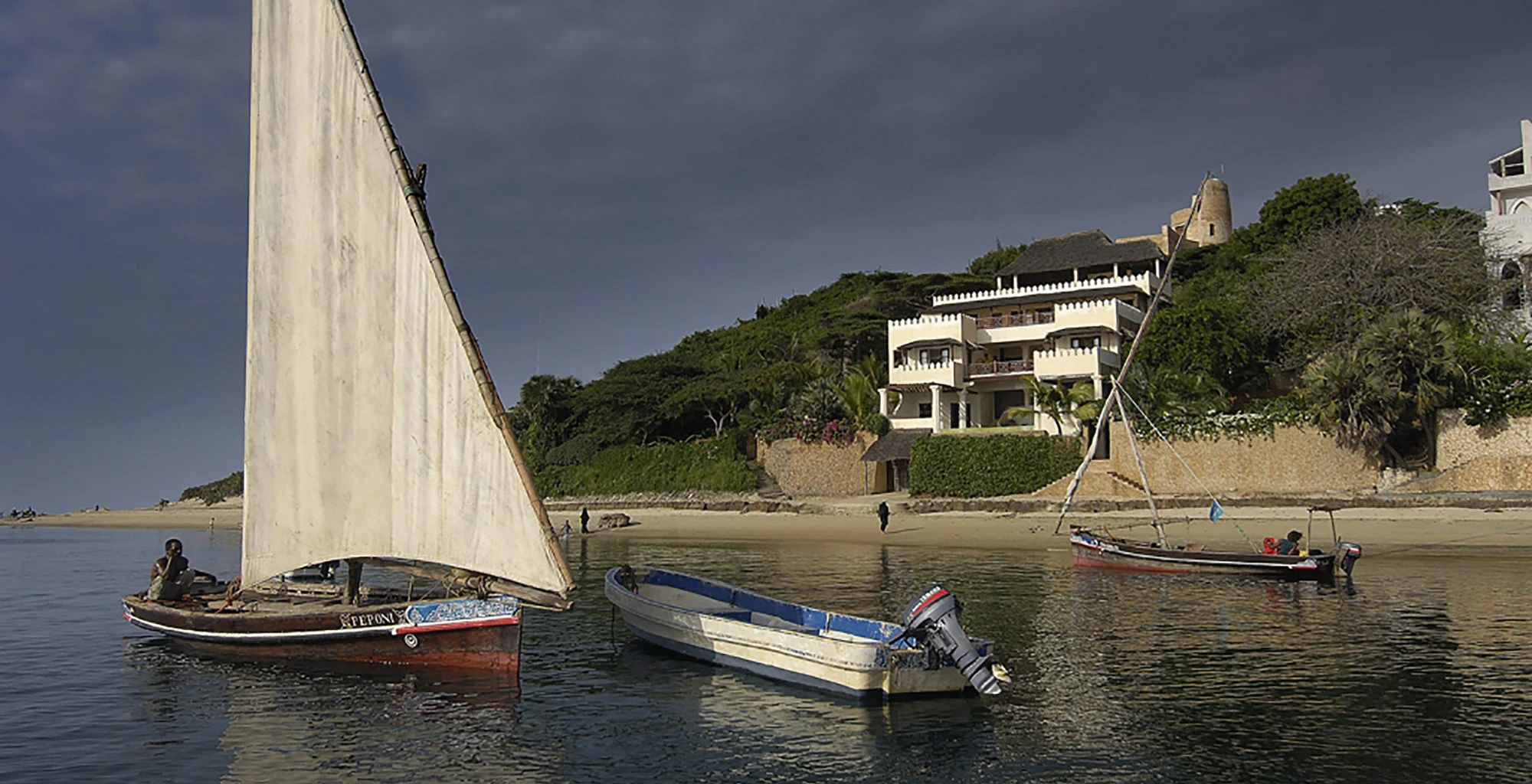 A dhow moored below whitewashed houses on the Lamu waterfront