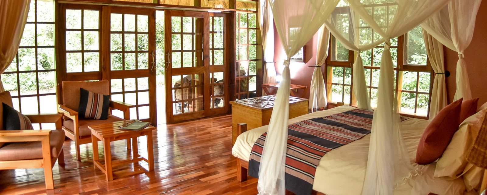 Tented bedroom with timber-framed windows at Primate Lodge Kibale