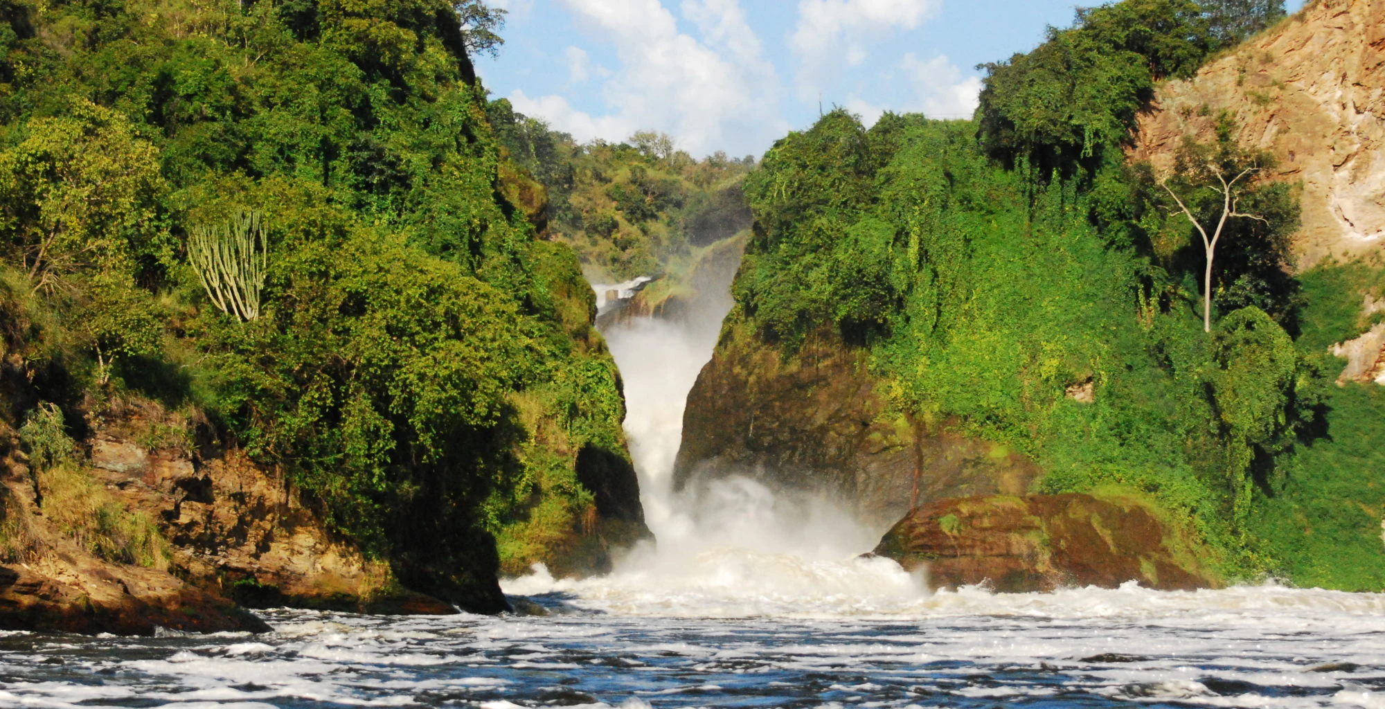 Murchison Falls pouring through a narrow gorge, seen from the Nile below
