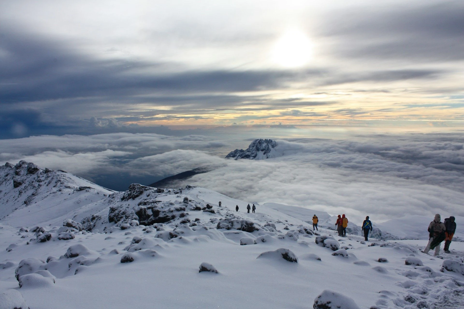 Climbers on a snowy ridge high above the clouds on Kilimanjaro