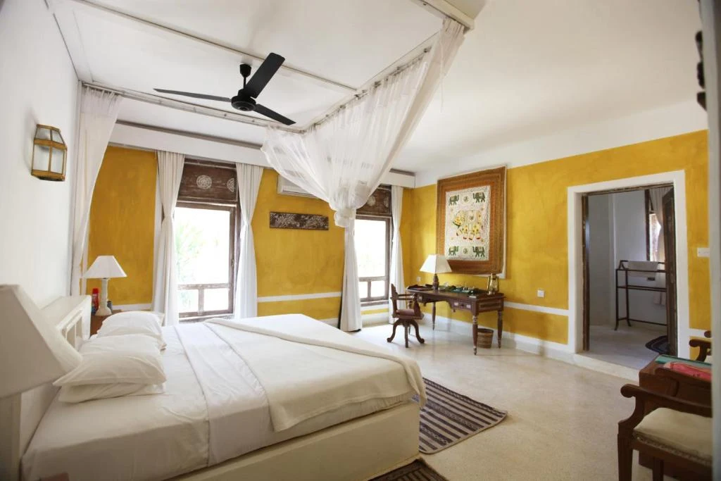 a bedroom with a large white bed and a desk