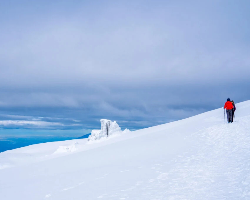 Lone climber in red on a snowy slope