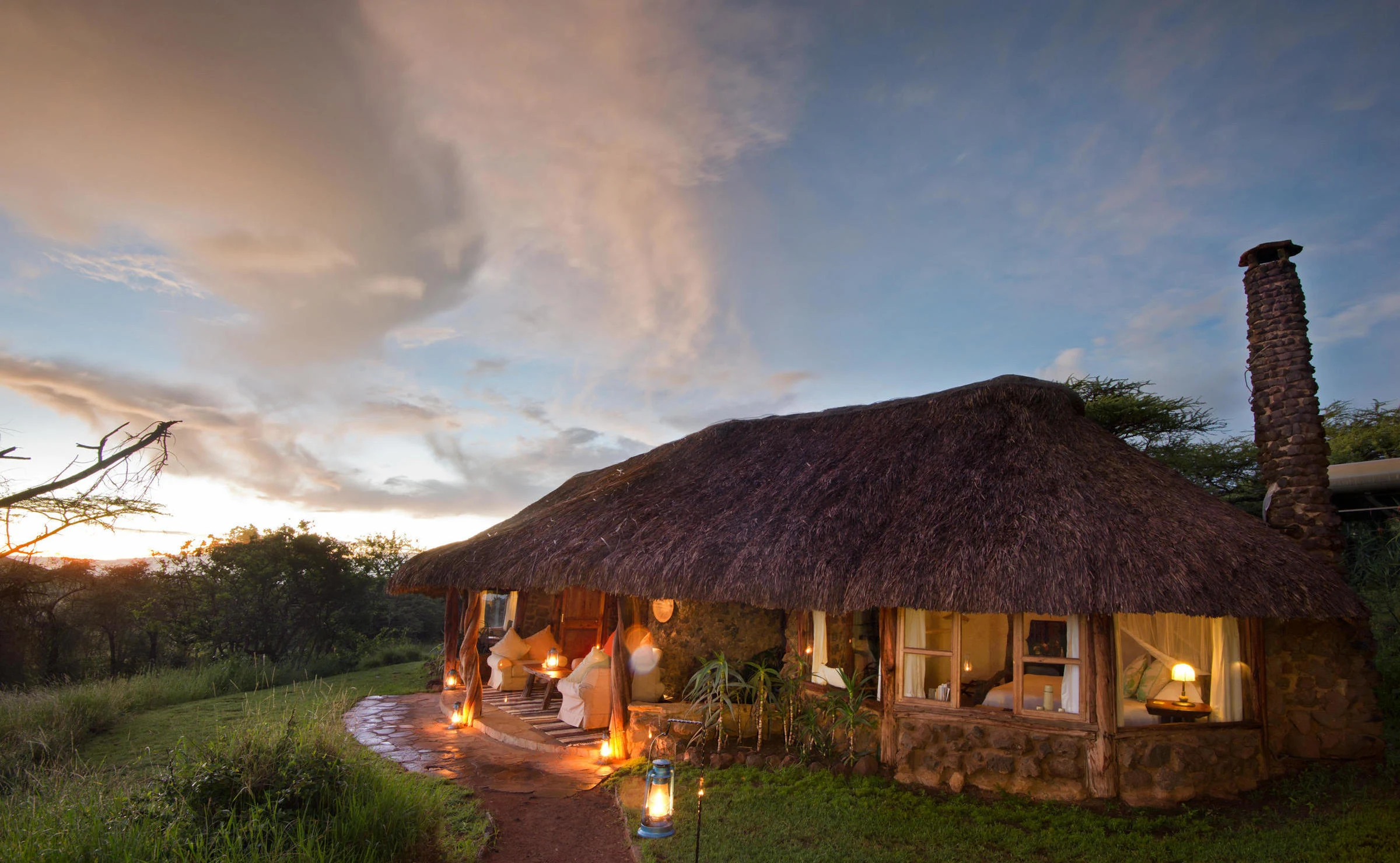 Round thatched cottage at dusk at Lewa House
