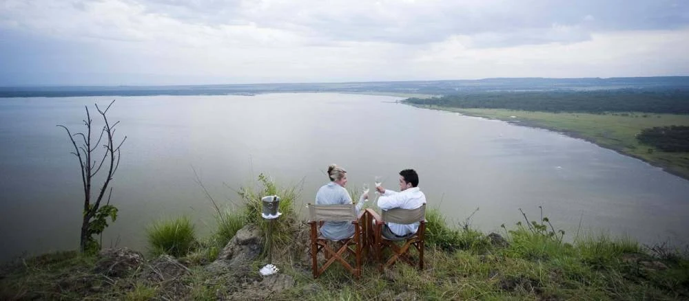 Two guests seated on a ridge above Lake Elementaita