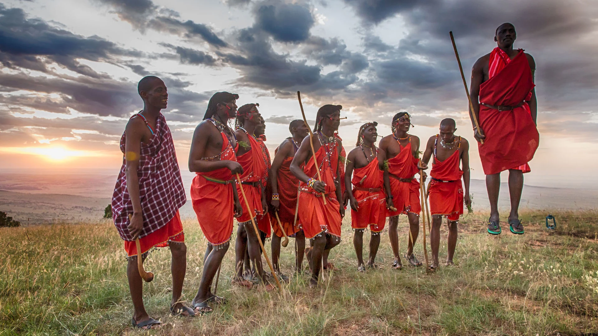 Maasai people in colourful cloth gathered at sunset
