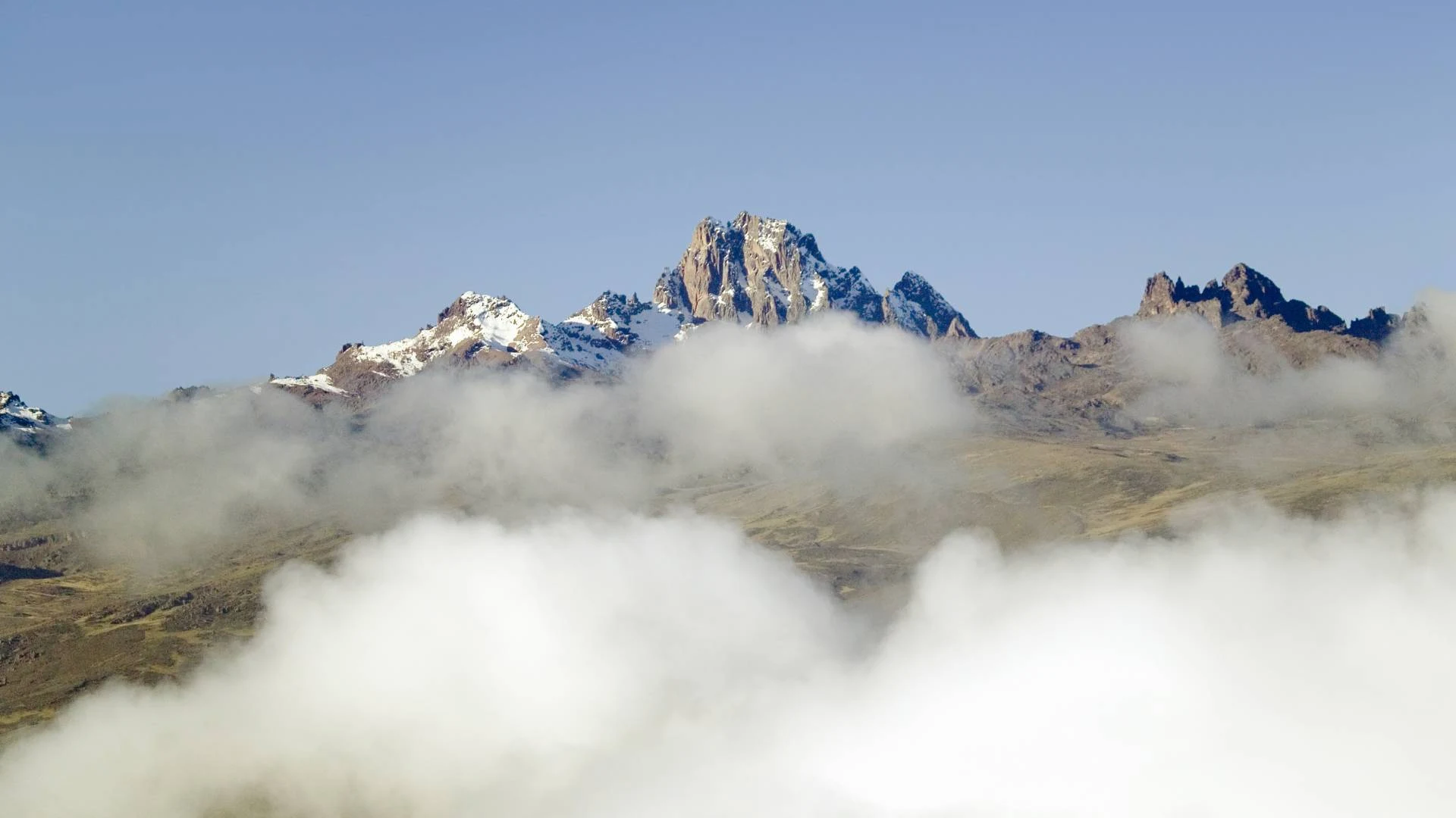 Mount Kenya's jagged summit peaks rising above the cloud, seen from the air