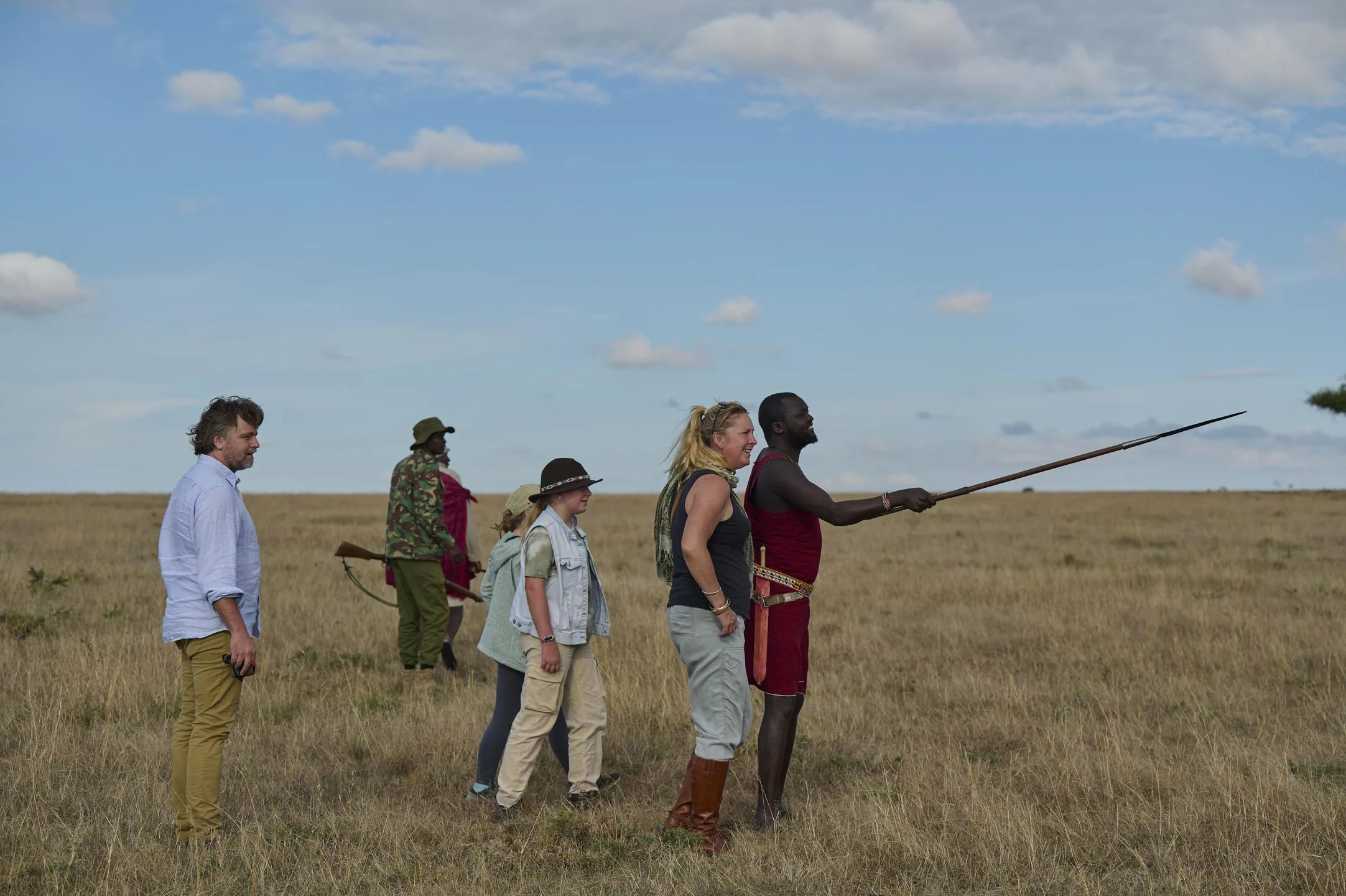 A Maasai guide pointing across the plains for a walking group in Naboisho