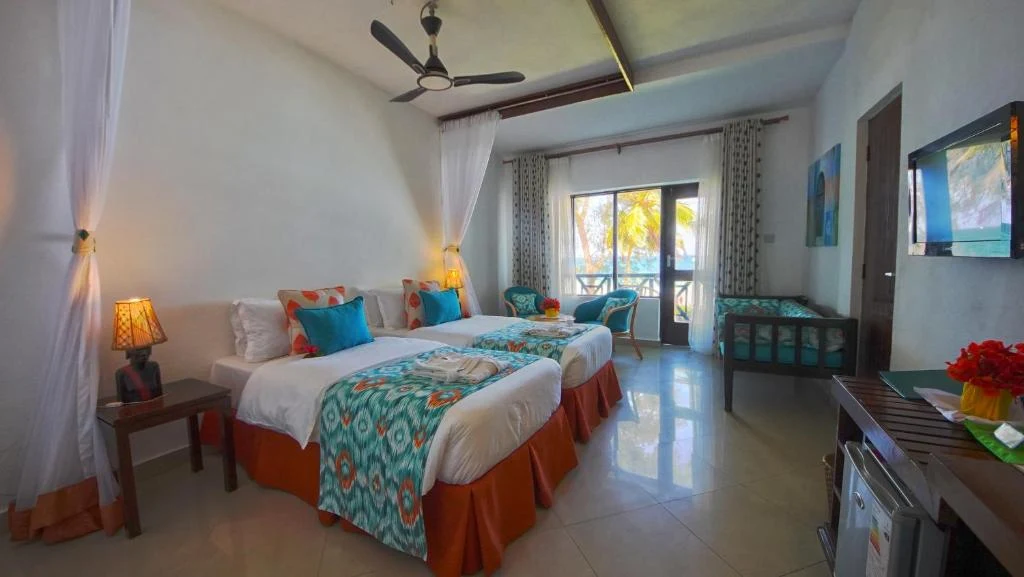 a bedroom with two beds and a television in it