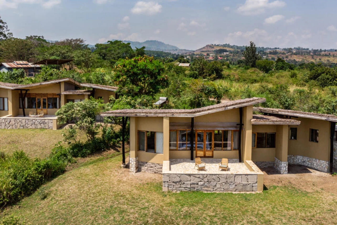 Stone cottages with broad patios at Kyambura Gorge Lodge
