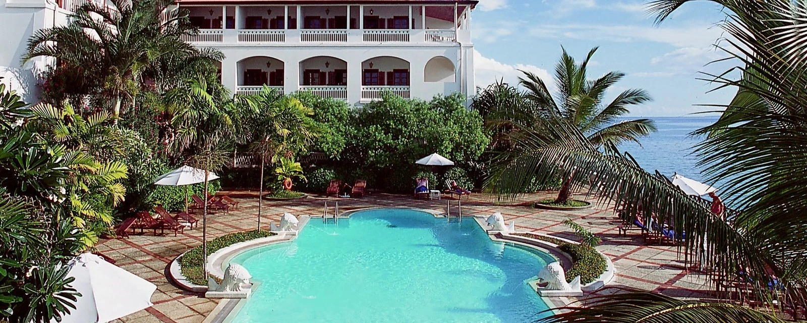 Courtyard swimming pool beside white hotel buildings at Zanzibar Serena Hotel
