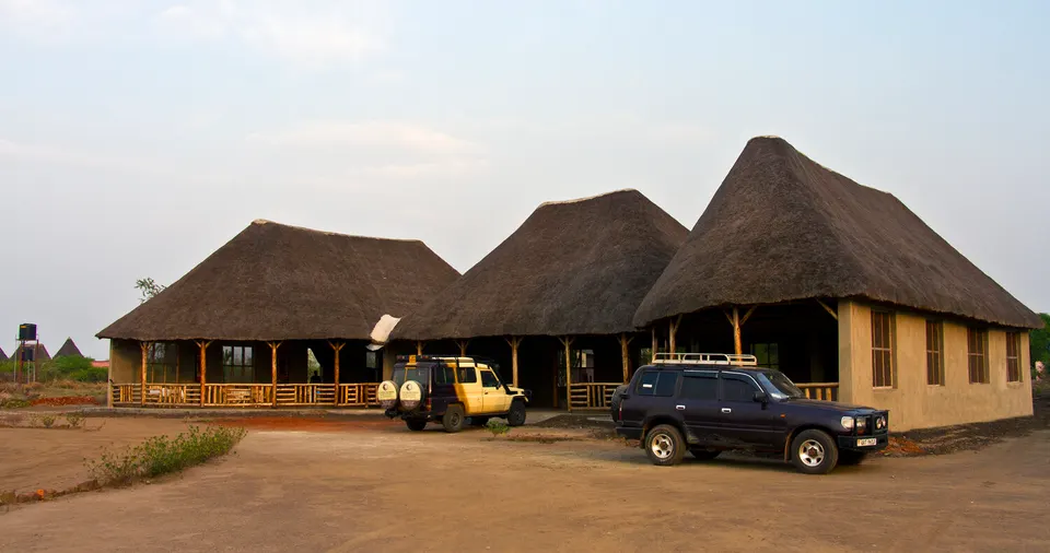 Euphorbia Safari Lodge main thatched building with parked vehicles