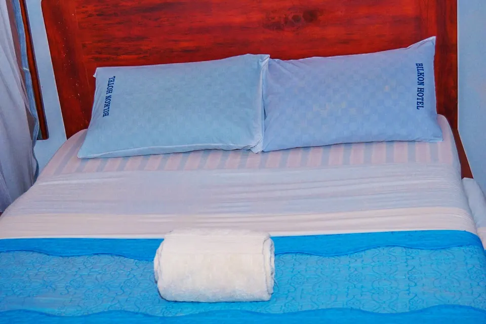 Prepared guest bed with hotel-branded linen