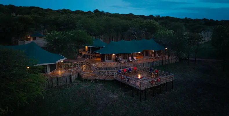 Enkirari camp buildings and deck at dusk
