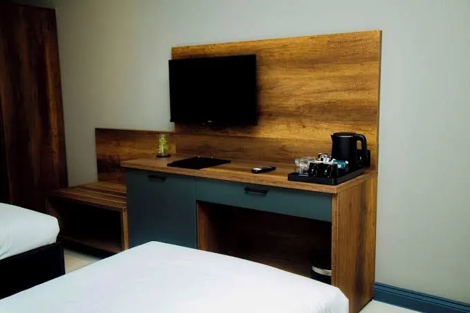 Guest-room desk, television and bed edge at New Amaan