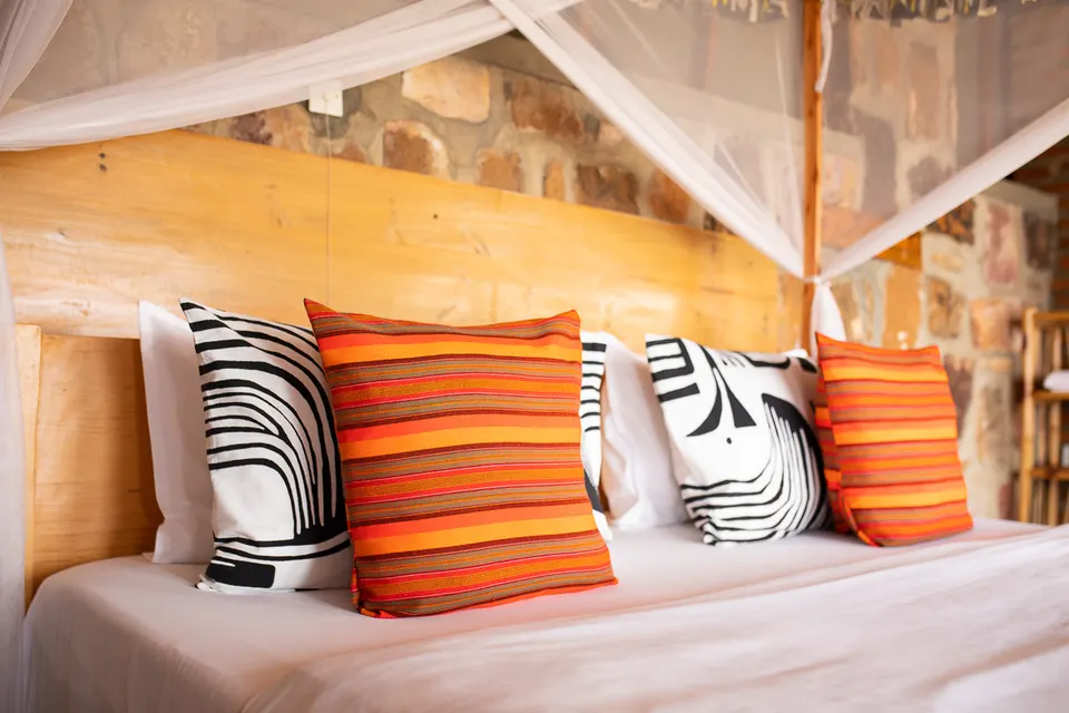 Akagera Rhino Lodge netted bed and stone wall