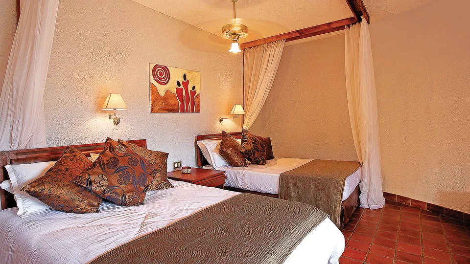 Guest room with two beds and mosquito nets
