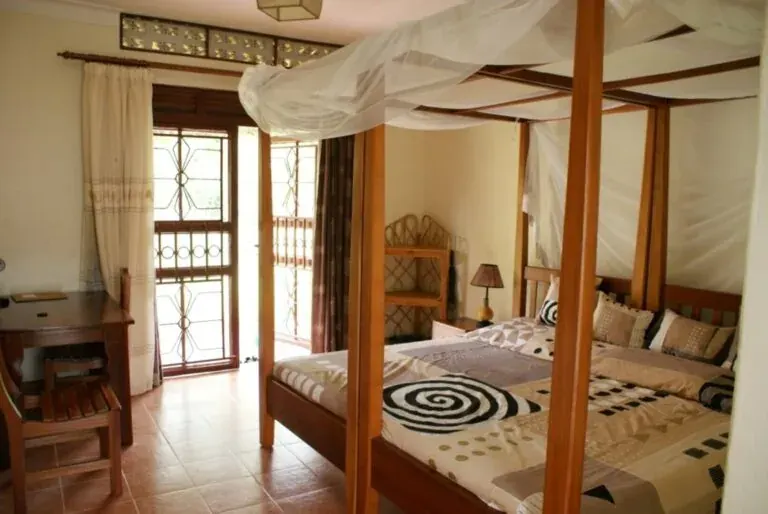 Airport Guesthouse Entebbe bedroom with netted bed and veranda doorway