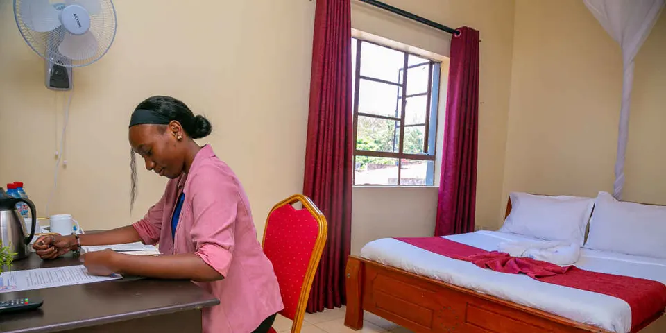 Museum View Hotel room with bed, desk and a seated person