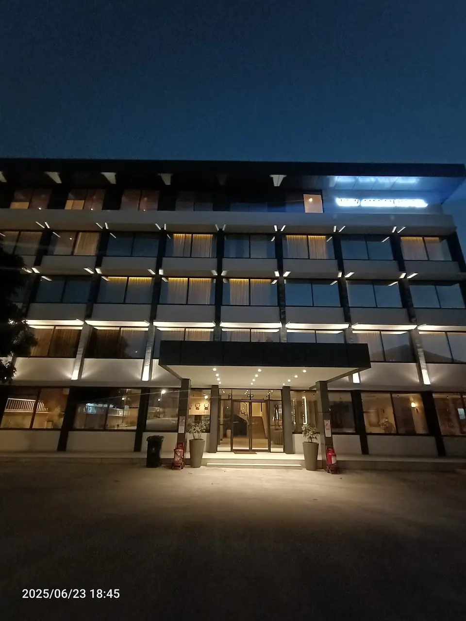 New Amaan Hotel exterior at night, name visible on facade