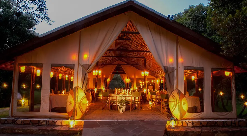 Sekenani Camp communal dining building illuminated at dusk