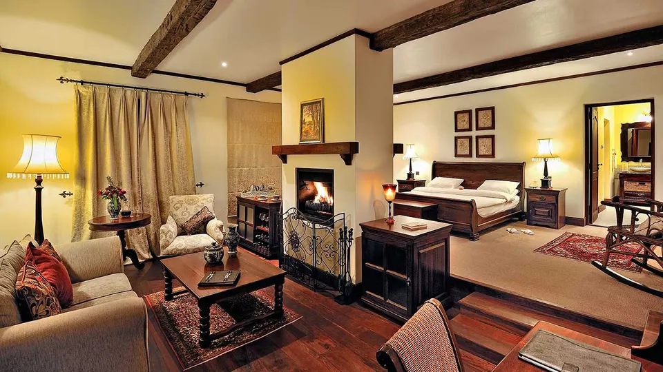 Manor Cottage Suite interior with bed, fireplace and lounge seating