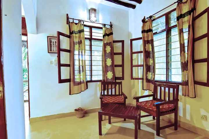 Room seating area and windows at Mangrove Lodge