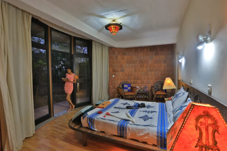 Guest bedroom with colourful textiles and broad windows