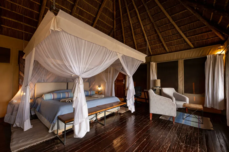 Room with timber floor and mosquito-netted bed
