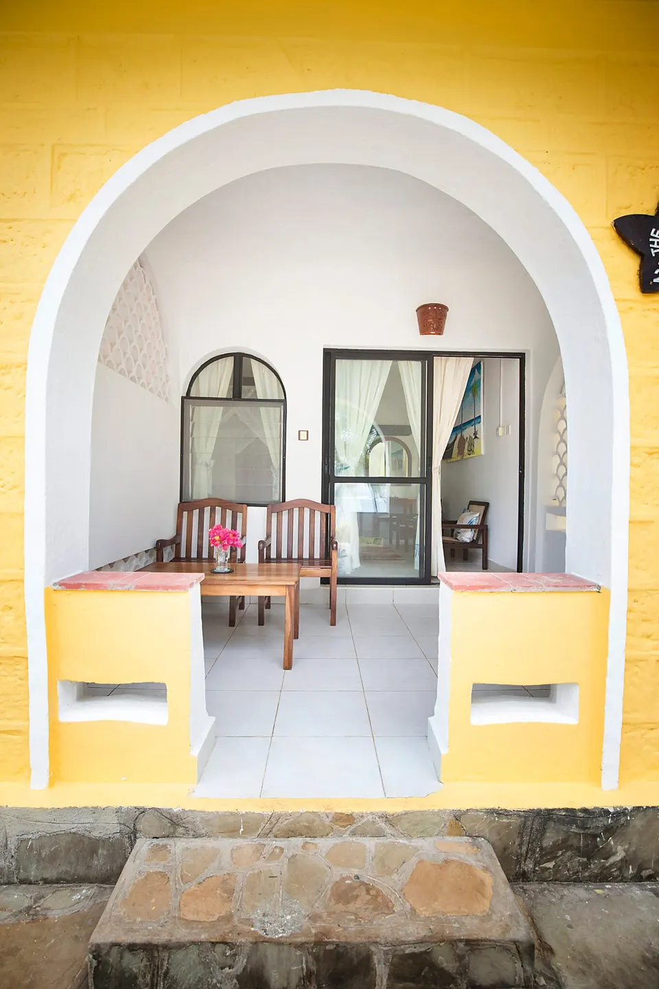 Coconut Beach Lodge furnished arched veranda; not a bedroom interior