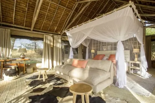 Kuro safari room with bed, sofa and mosquito canopy