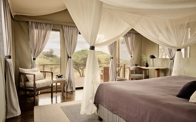 New2026 tented suite interior with bed, seating and glazed doors