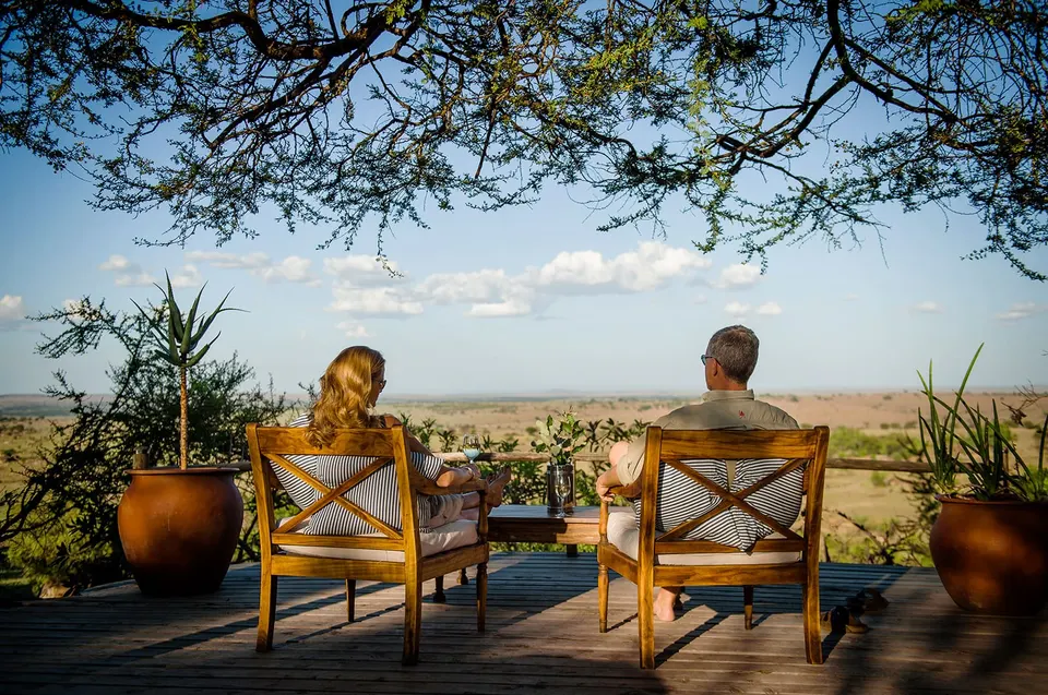 Outdoor veranda seating and guests overlooking the plains at Lamai